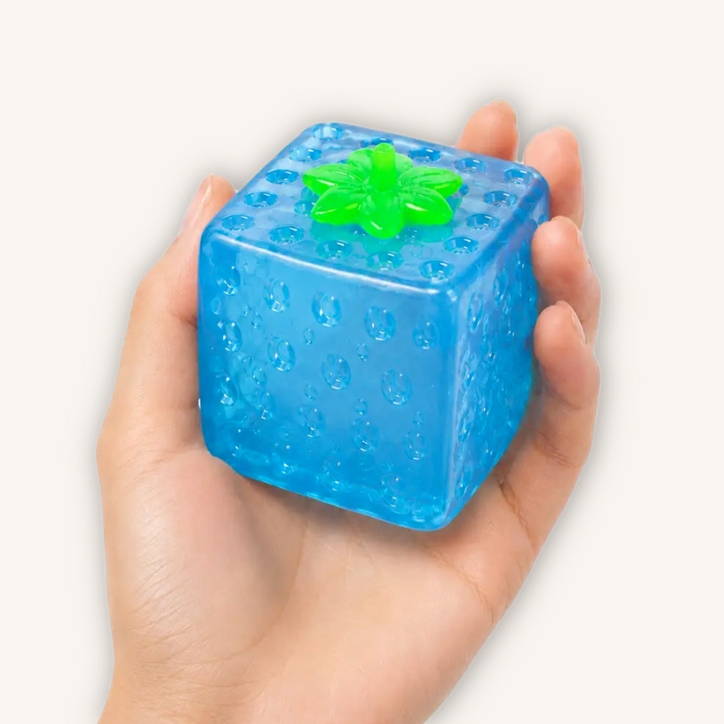 Blue Top Trenz Sugar Squisher Fruit Cube held in hand, showing its textured surface and soft sugar gel sensory filling.